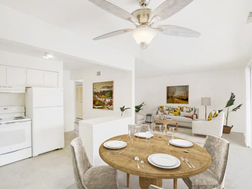 a dining area with a wooden table and chairs and a kitchen in the background