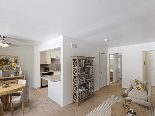 a spacious living room with a kitchen in the background