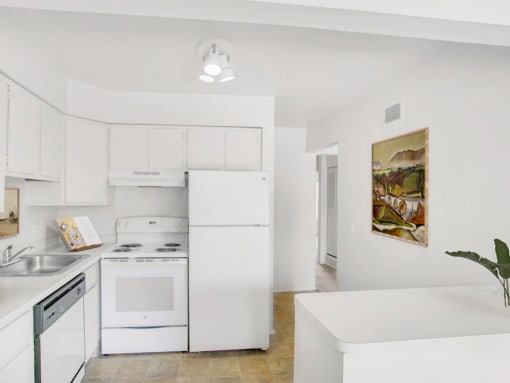 a kitchen with white cabinets and a white stove top oven