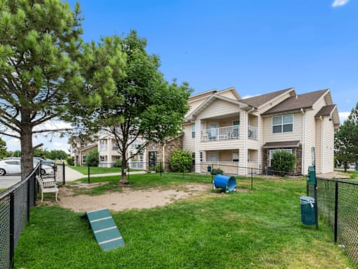 A large house with a green lawn and a slide in the yard.