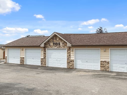 A building with the number 1105 on it has four garage doors.