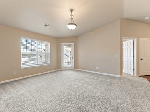 A spacious room with a carpeted floor and a ceiling light.