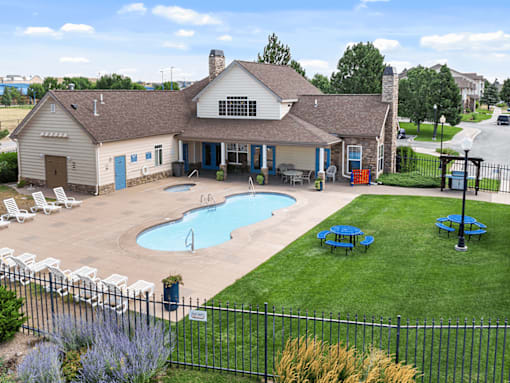 A pool and patio area in front of a house.