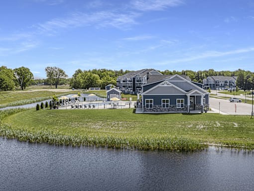A building with a grey roof is situated by a body of water.