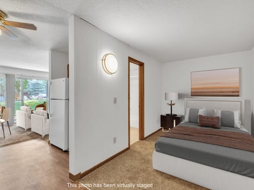 a bedroom with a bed and a door to a living room