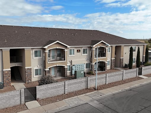 A row of houses with brown roofs and beige walls.
