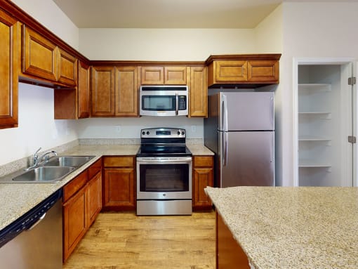 a kitchen with wooden cabinets and stainless steel appliances