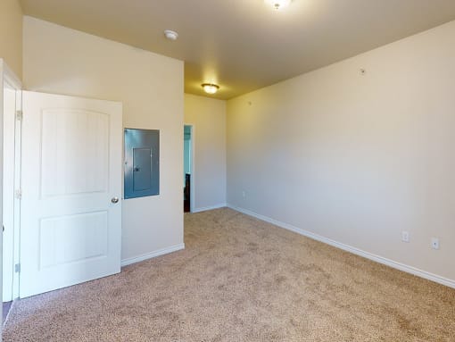 a bedroom with a white door and a carpeted floor