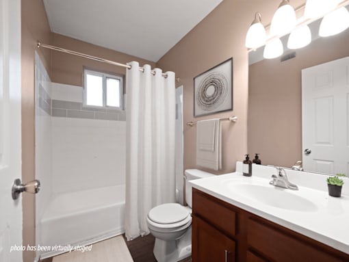 A bathroom with a toilet, sink, and shower.