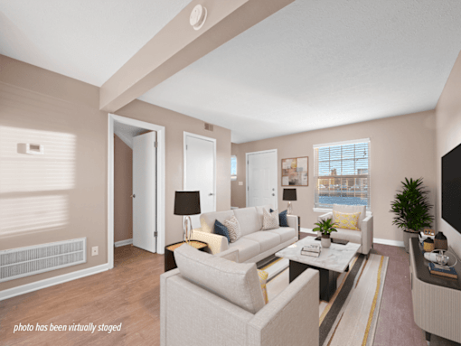 A living room with a white couch and a coffee table.
