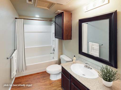 A bathroom with a white toilet, sink, and a mirror.