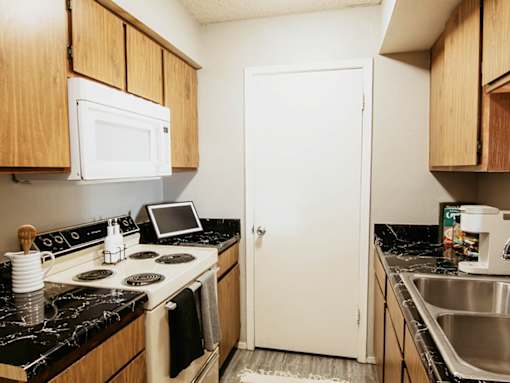 A kitchen with a stove, microwave, and sink.