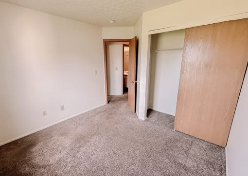 an empty living room with white walls and doors