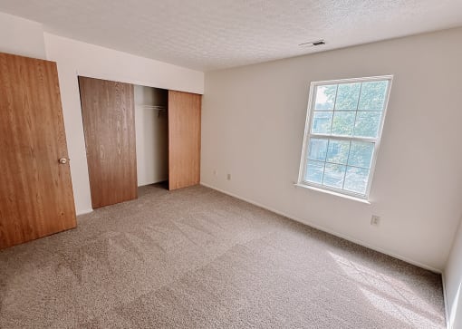 an empty room with a door and a window
