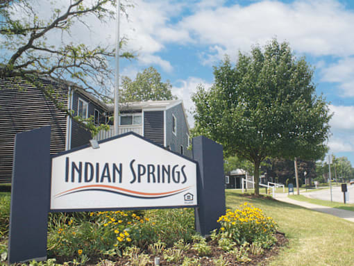 A sign that says Indian Springs in front of some houses.