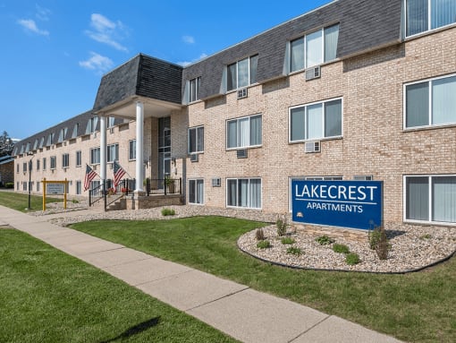 a large brick building with a lake crest apartments sign in front of it