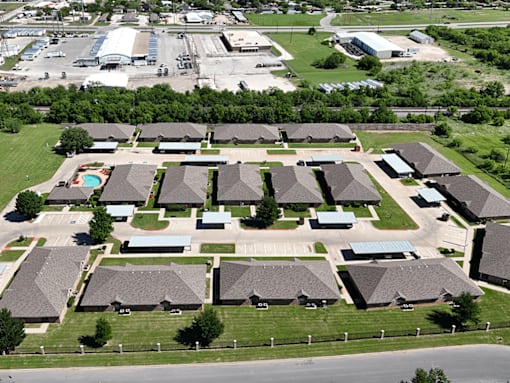 A bird's eye view of a residential area with houses and a swimming pool.