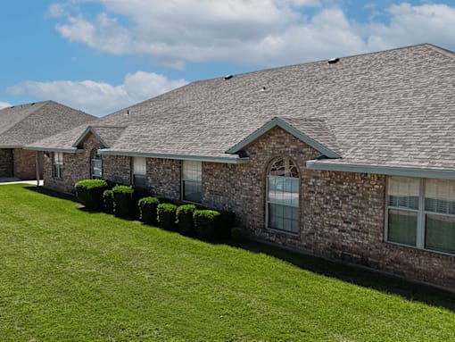 A row of houses with green lawns in front.