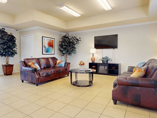 A living room with a brown leather couch and a coffee table.
