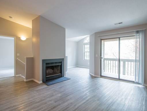 A spacious living room with a fireplace and sliding glass doors.