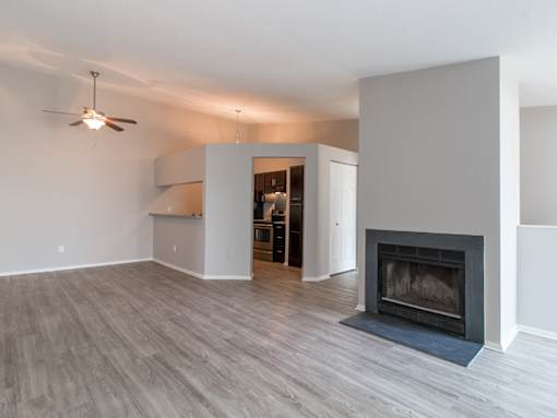 A living room with a fireplace and a ceiling fan.