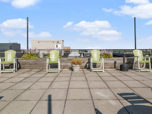 the roof terrace has several chairs and plants on it
