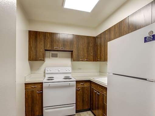 A kitchen with a white stove and refrigerator.