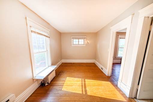 A room with a window and a wooden floor.