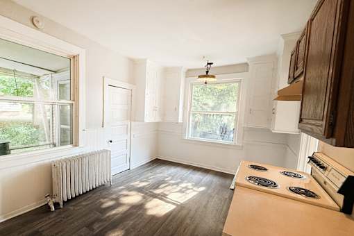 A sunny room with a stove and a window.