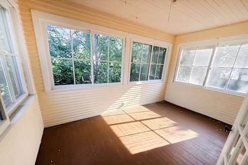 A sunny room with wooden floors and white walls.