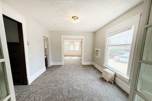 A room with a carpeted floor and a window.