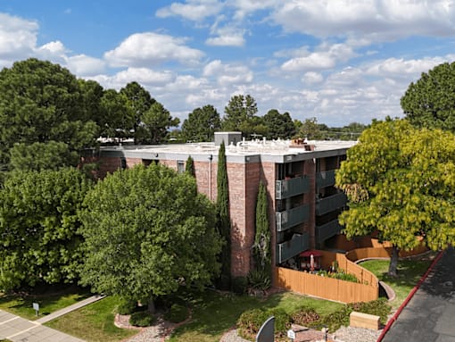 A large apartment complex with a parking lot in front.
