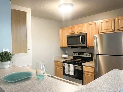 A kitchen with a stove, microwave, and refrigerator.