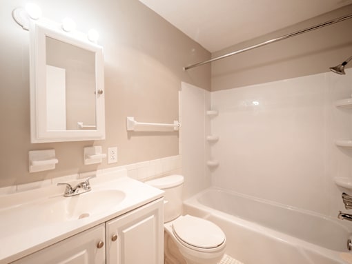 A white bathroom with a toilet, sink, and bathtub.