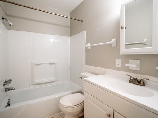 A white bathroom with a toilet, sink, and bathtub.