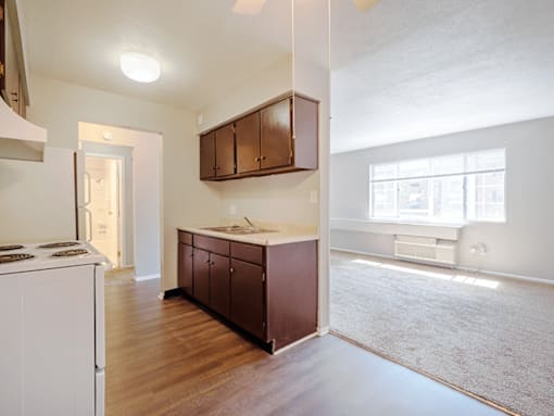 A kitchen with white appliances and brown cabinets.