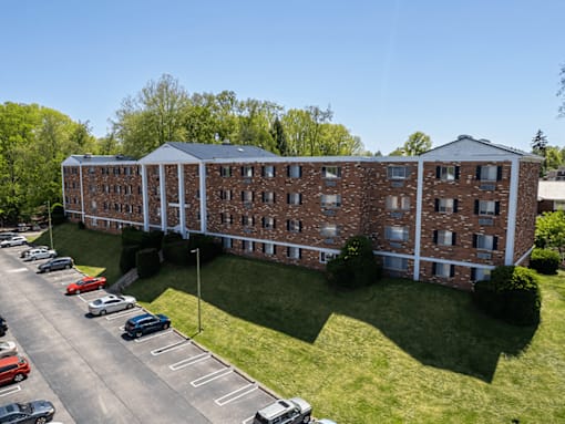 A large brick building with a parking lot in front.