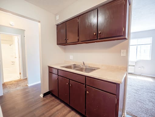 A kitchen with brown cabinets and a white counter top.