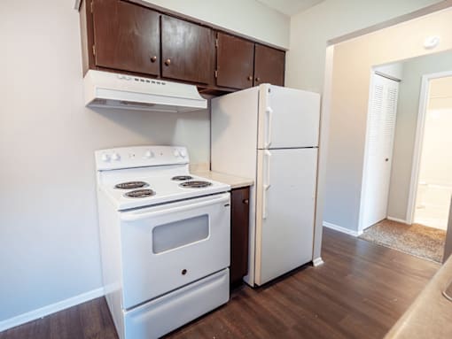 A white stove and refrigerator in a kitchen.