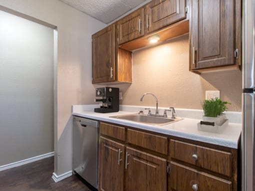 a kitchen with wooden cabinets and a stainless steel dishwasher