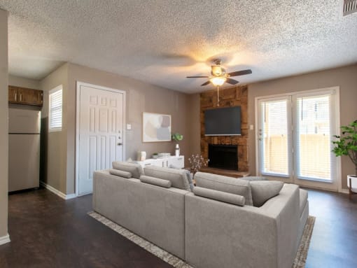 a living room with a couch and a tv in front of a fireplace