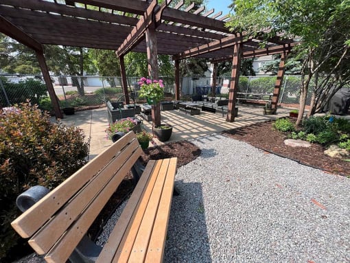 a park with a wooden bench and a pergola