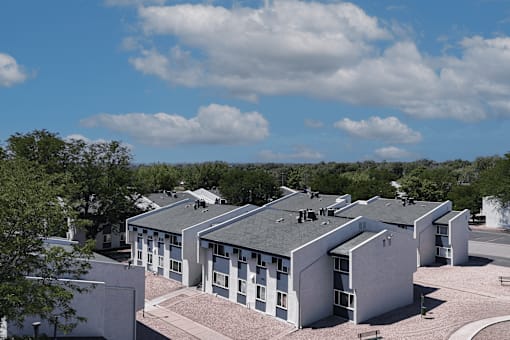 A building complex with a grey roof and white walls.
