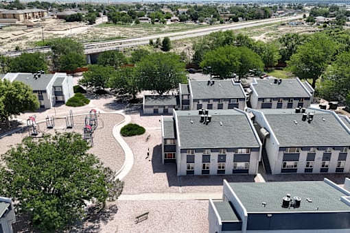 A playground area is surrounded by apartment buildings.