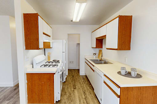 A kitchen with white appliances and wooden cabinets.