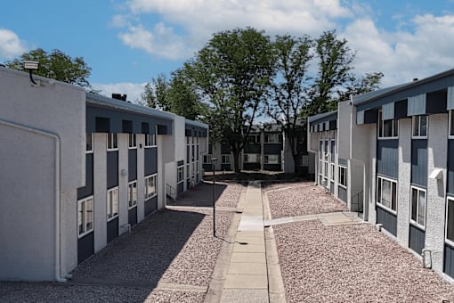 A long corridor with a pathway in the middle of apartment buildings.