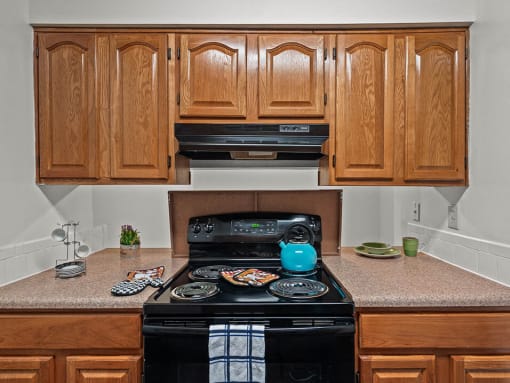 a kitchen with wooden cabinets and a black stove