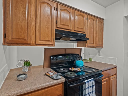 a kitchen with wooden cabinets and a black stove and oven