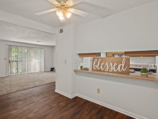 an empty living room with a sign on the wall