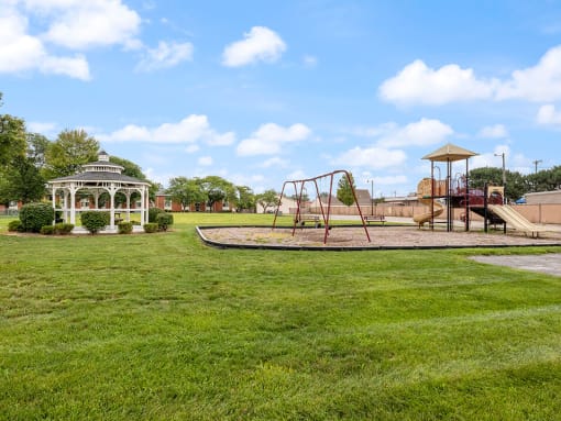 a playground with a gazebo and a swing set